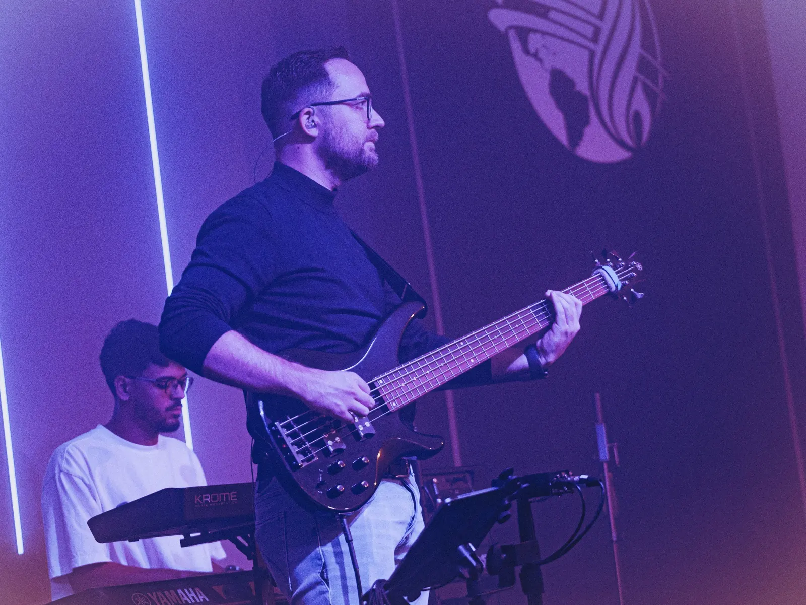 Bassist en toetsenist van de band in paars licht